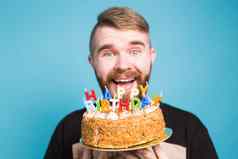 疯狂的有趣的积极的的家伙赶时髦的人持有快乐生日蛋糕手站蓝色的背景概念笑话假期