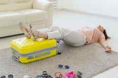 假期旅行假期概念女人关闭手提箱很多的事情
