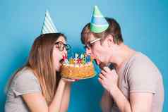 奇怪的年轻的夫妇女孩男孩纸帽子咬一块祝贺的蛋糕生日祝贺你概念