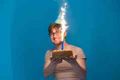 疯狂的快乐的的家伙学生眼镜问候纸他持有蛋糕燃烧烟花手假期生日概念