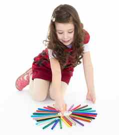 女孩坐着地板上玩彩色的笔