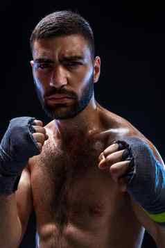 拳击男人。准备好了战斗拳击手强大的手握紧的拳头蓝色的肩带黑色的背景