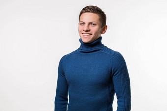 工作室拍摄年轻的男人。穿蓝色的高领毛衣毛衣
