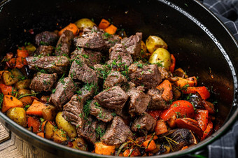 牛肉肉蔬菜炖肉黑色的烘焙菜木背景前视图