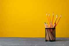 办公室杯铅笔文具黄色的背景