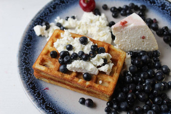 美味的健康的早餐比利时软华夫饼凝乳奶酪奶油蓝莓樱桃谎言白色蓝色的板视图前美味的生活
