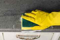 女人的手黄色的手套清洁计数器前厨房
