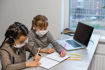 年轻的小学学校女孩脸保护面具看在线教育类冠状病毒科维德封锁教育概念