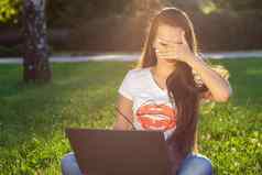 年轻的女人电脑绿色草公园教育学习自由工作户外放松概念的想法背景太阳耀斑