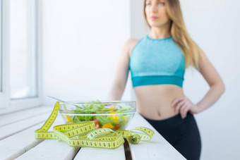 健康的生活方式健身饮食概念特写镜头饮食沙拉andmeasuring磁带女人体育穿背景