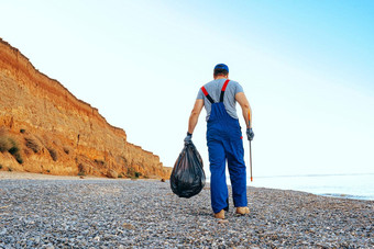 男人。志愿者收集垃圾海滩达到扩展器坚持