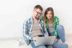 微笑年轻的夫妇使在线购买家具抵押贷款公寓在线购物概念移动PC小工具
