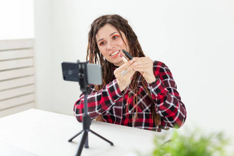 写博客视频博客化妆品概念年轻的女人博主会说话的相机黑色的口红