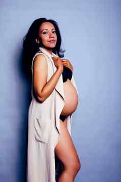 年轻的漂亮的非洲美国女人怀孕了快乐微笑及功率