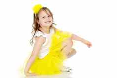 女孩黄色的裙子坐在地板上