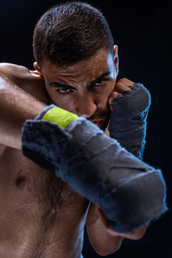 拳击手准备好了交易强大的打击照片肌肉发达的男人。强大的手握紧的拳头蓝色的条纹黑色的背景