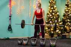 运动女孩提出了权重健身房装饰圣诞节树体育假期