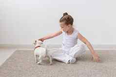 宠物孩子们动物概念迷人的孩子女孩坐着地板上喂养小狗