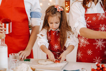 女孩红色的围裙一年的厨房准备面团圣诞节饼干