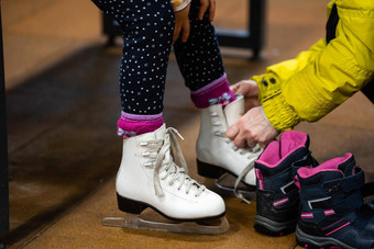 家庭冬天公园妈妈。女儿冰竞技场妈妈把女儿溜冰鞋
