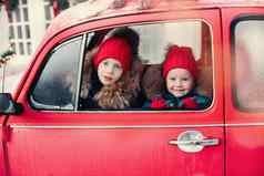 微笑可爱的冬天男孩女孩孩子们红色的他坐着车有趣的