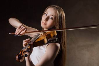美丽的年轻的女人玩小提琴黑色的