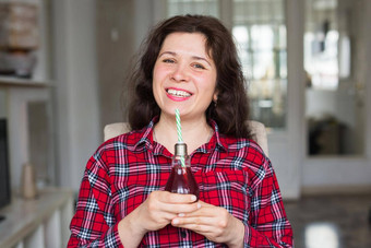 饮食健康的生活方式排毒概念年轻的女人樱桃汁瓶灯