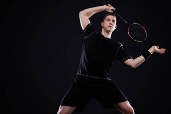 羽毛球球员运动服装球拍羽毛球黑色的背景