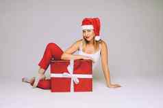 有趣的女人圣诞节他坐在大红色的盒子图片孤立的白色背景