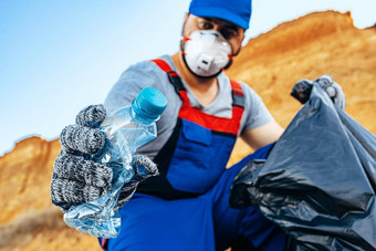 手男人。志愿者抓住塑料垃圾浪费袋清洁海滩