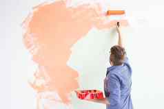 修复公寓男人。油漆墙油漆回来视图复制空间