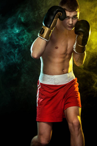运动员男人。拳击手战斗手套黑色的背景颜色烟复制空间