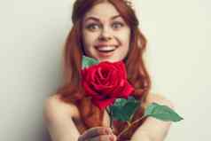 美丽的女人红色的头发红色的玫瑰花关闭