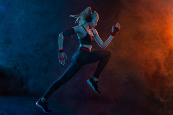 短跑运动员运行强大的运动女人运行黑色的背景穿运动服装健身体育运动动机跑步者概念