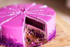 粉红色的紫罗兰色的生日蛋糕一块甜点假期美味的概念