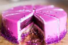 粉红色的紫罗兰色的生日蛋糕一块甜点假期美味的概念