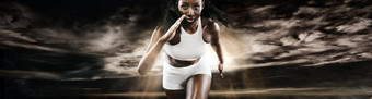 强大的运动女人短跑运动员运行黑暗背景穿运动服装健身体育运动动机跑步者概念