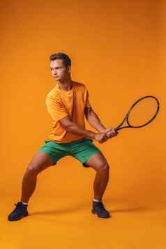 全身的肖像网球球员男人。行动橙色背景