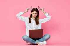 女人移动PC坐着地板上互联网沟通在线粉红色的背景