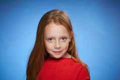 快乐的可爱的红发女孩童年蓝色的背景