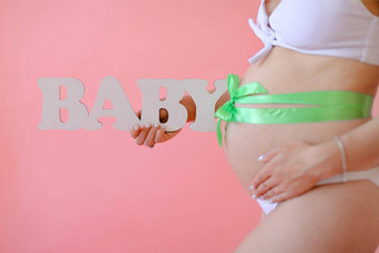 特写镜头怀孕了女人白色内衣丝带肚子保持登记婴儿