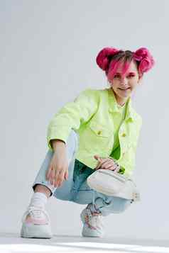 快乐的女人粉红色的头发摆姿势时尚衣服生活方式有趣的设计