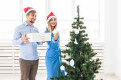 假期节日概念年轻的家庭夫妇装修圣诞节树