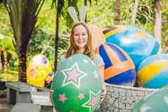 美丽的年轻的女人兔子耳朵有趣的传统的复活节鸡蛋亨特在户外庆祝复活节假期