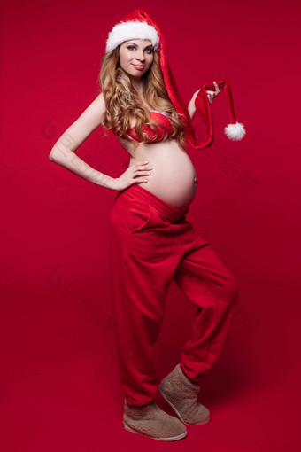 美丽的怀孕了女人金发碧眼的头发摆姿势红色的一年的服装