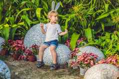 可爱的孩子男孩兔子耳朵有趣的传统的复活节鸡蛋亨特在户外庆祝复活节假期蹒跚学步的发现色彩斑斓的鸡蛋