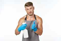 运动肌肉发达的男人。穿围裙洗涤剂清洁