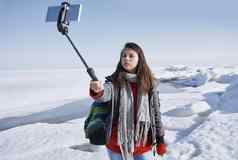 女旅行者在户外冰冷的景观独脚架使自拍图片