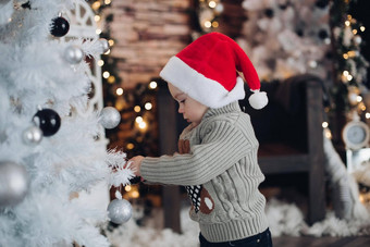 可爱的男孩装修大一年的白色圣诞节树