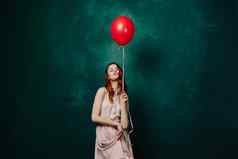 漂亮的女人衣服红色的气球生日绿色背景